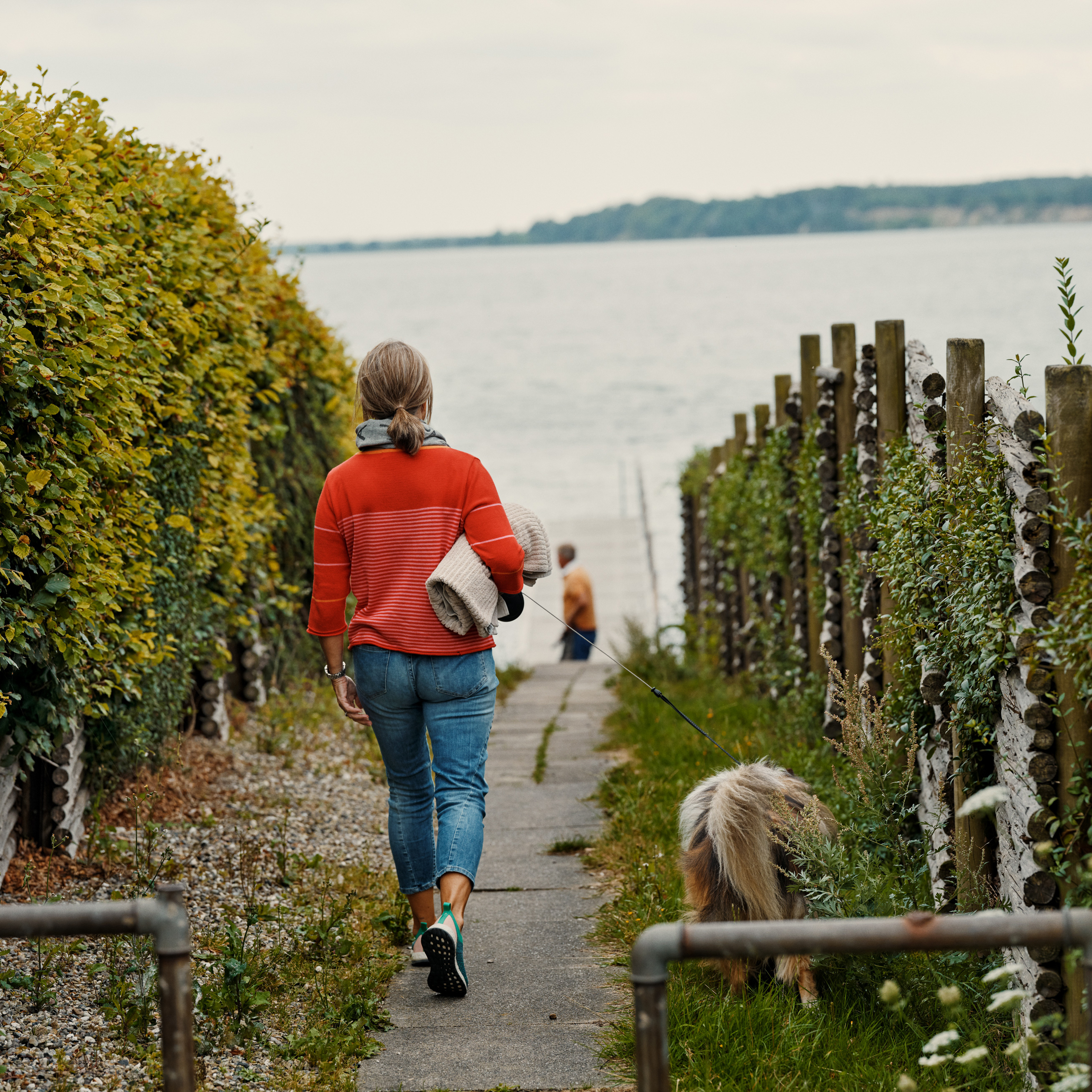 Kvinde og hund på vej til havet, natur, gåtur 