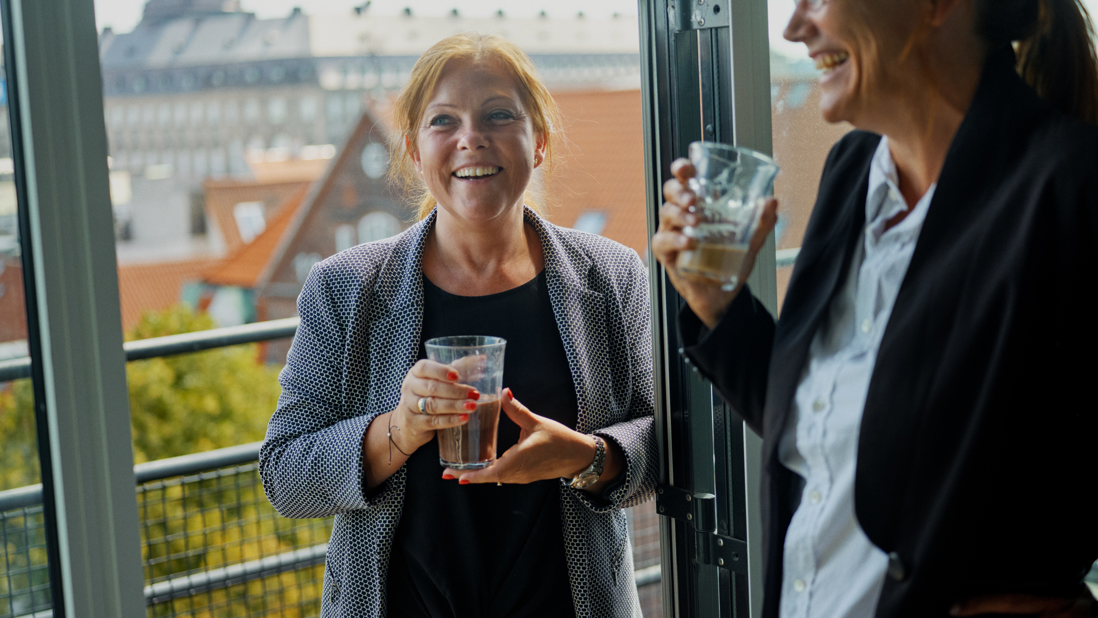 To kvindelige pensionsrådgivere fører en samtale over en kop kaffe