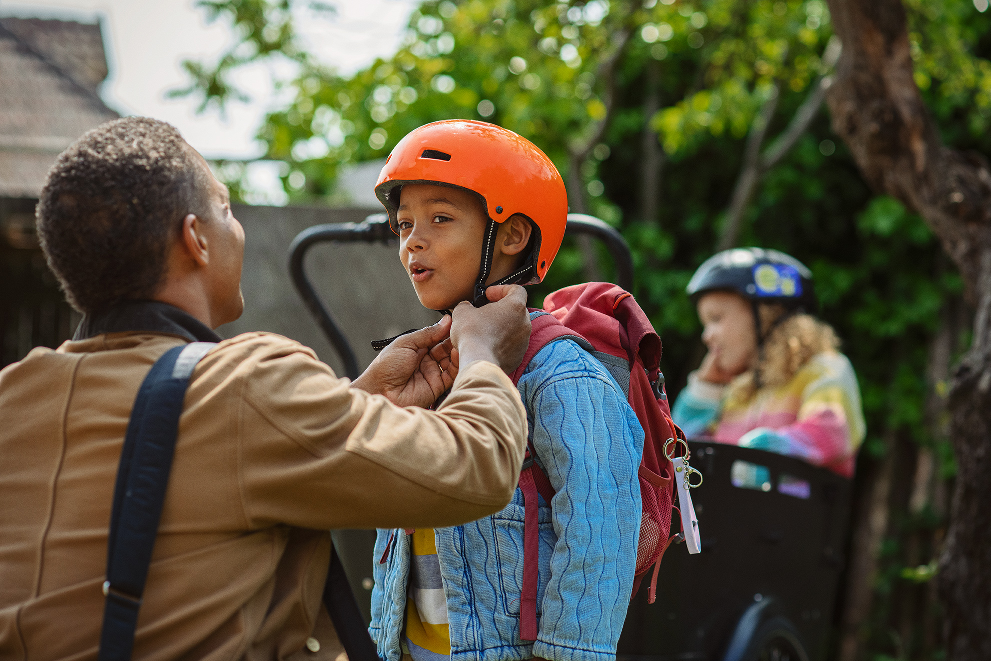 Far hjælper sin søn med at tage cykelhjelm på